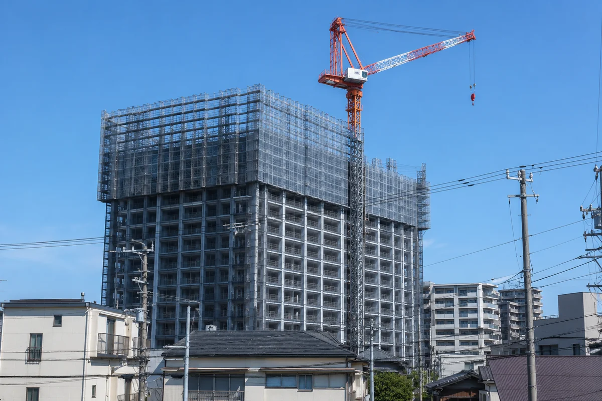 建設中の高層マンションとタワークレーン。マンション施工に強い準大手ゼネコンのイメージ